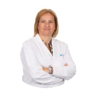 Dr Ana Teresa Almeida Santos, PhD, coordinatrice scientifique et spécialiste en obstétrique, gynécologie et médecine de la reproduction à la clinique Eugin Coimbra, portant une blouse blanche, bras croisés, sur fond blanc.