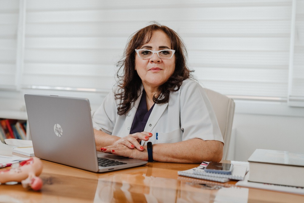 Dr Serap Kagan, spécialiste en fertilité au Cyprus IVF Hospital, assise à son bureau avec un ordinateur portable, prête à accompagner les patients dans leur parcours de procréation assistée.