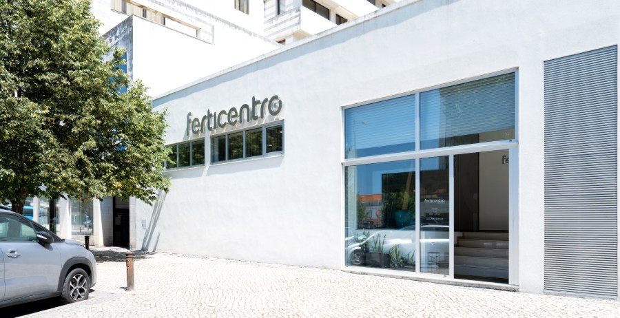 Vue extérieure de la clinique de fertilité Ferticentro à Coimbra avec bâtiment blanc, grande entrée vitrée et logo sur la façade.
